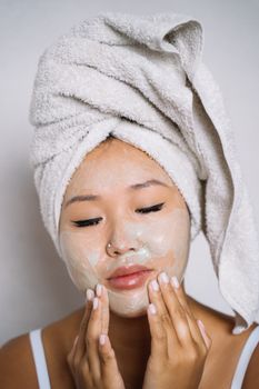 A woman applying cream during a skincare routine for relaxation at home.
