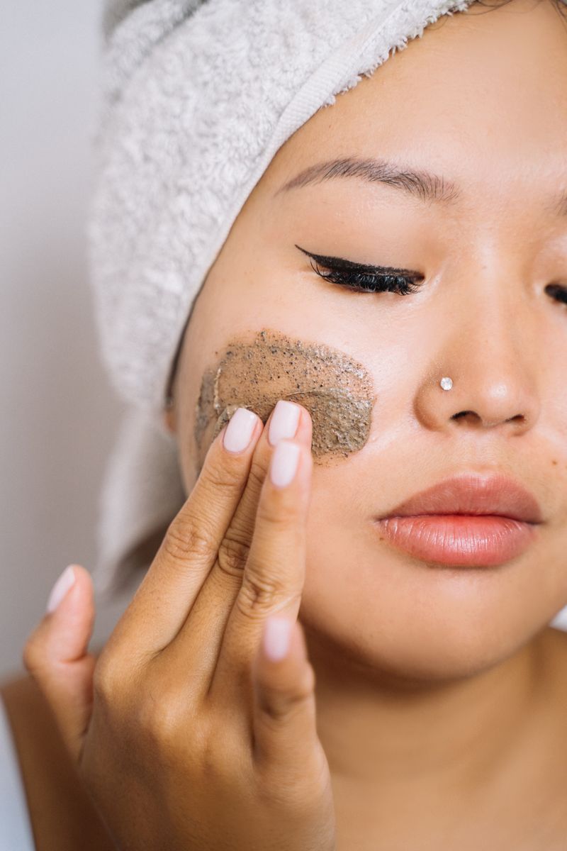 Woman applying an exfoliant to her cheek
