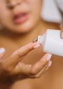 Person Holding White Plastic Bottle