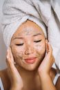Woman With White Towel on Head Scrubbing Her Face