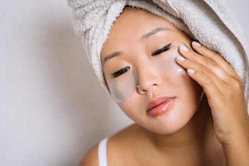 Woman With Towel on Head Putting Under-Eye Mask 