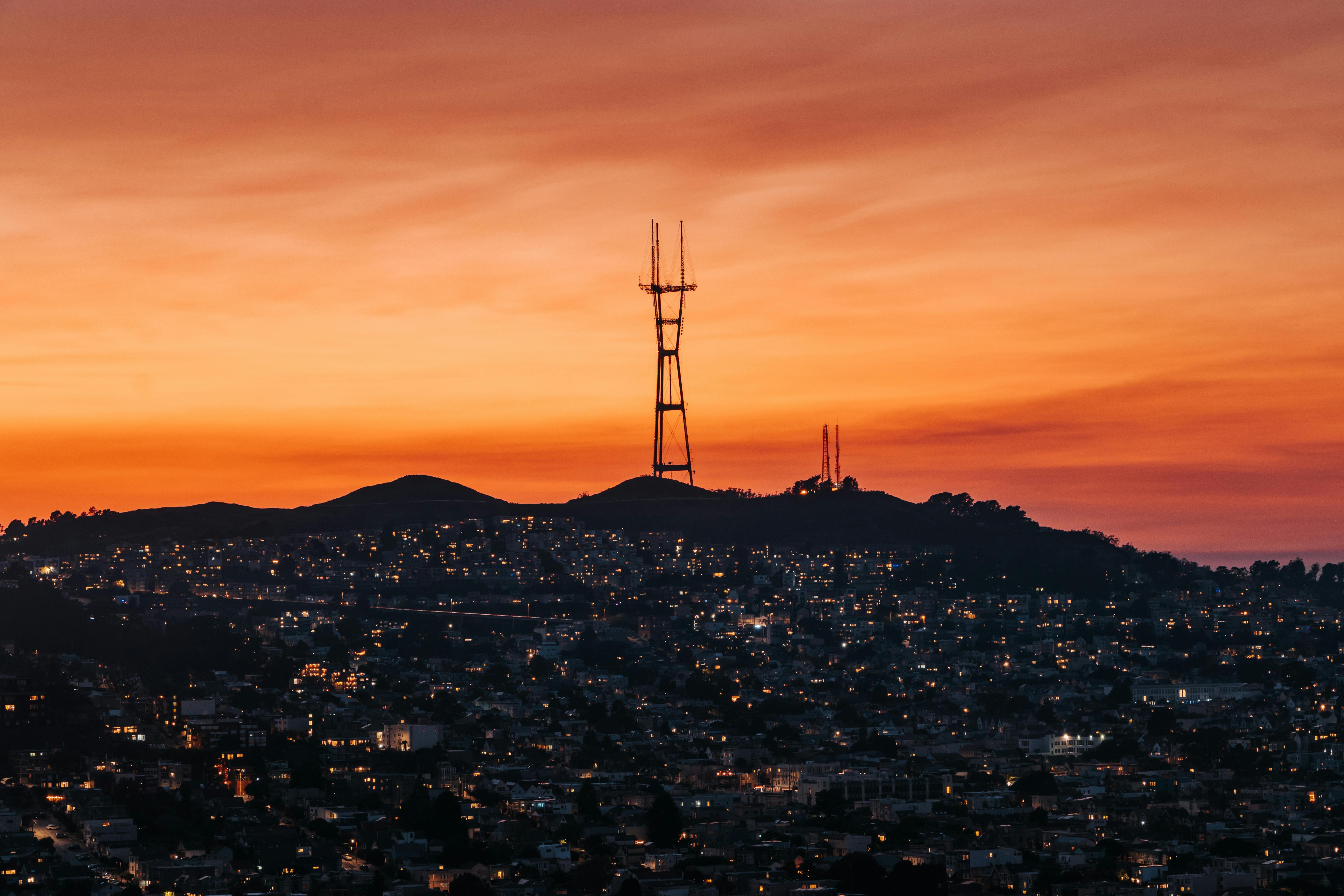 Sutro Tower overlooking San Francisco's urban landscape with a vibrant sunset sky.