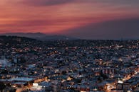 Illuminated city under bright sundown sky