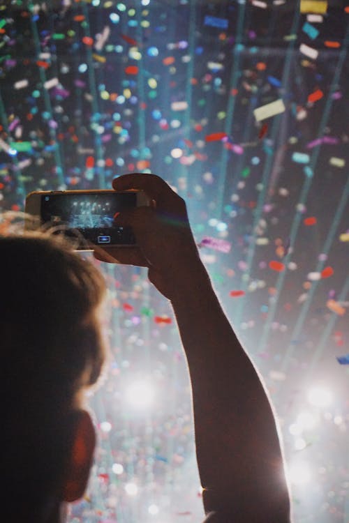 
A Man Taking a Picture of Confetti in the Air