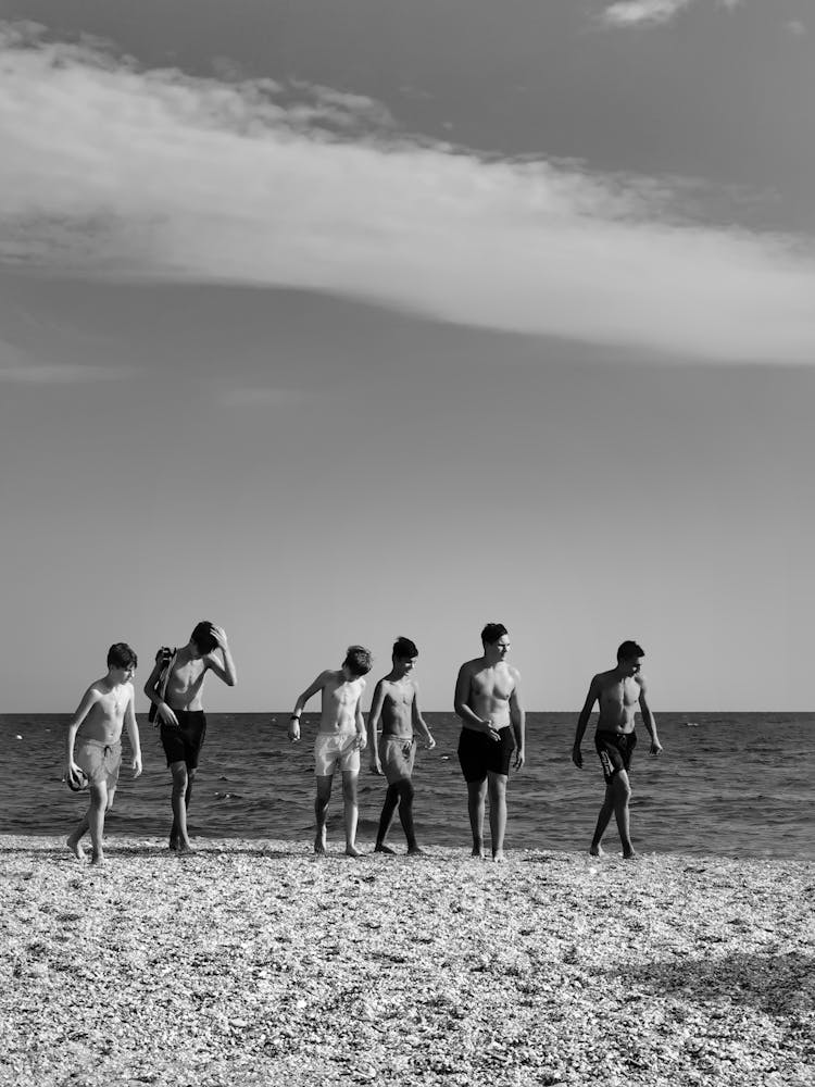 Group Of Men Walking On The Beach