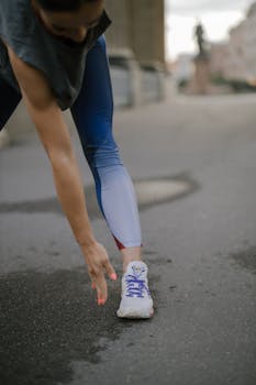 Woman engaged in a stretching routine outdoors, wearing colorful activewear and sneakers.