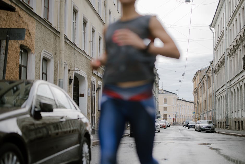 Garmin Forerunner 265 vs Coros Pace 3: GPS Accuracy for Trail Running (2024) A blurred runner in activewear dashes through a serene urban street, symbolizing vitality.