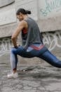 Woman in Gray Tank Top and Blue Leggings Doing Yoga