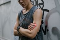Woman in Gray Tank Top Wearing Black Round Analog Watch