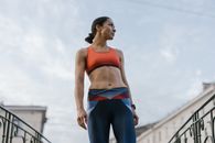 在晴朗的天空下，一位穿着运动服的女人自信地站在户外