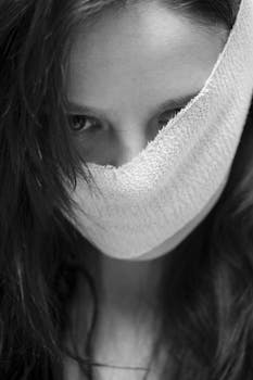 一张黑白照片中，长发女人的脸被部分遮住，营造出神秘氛围