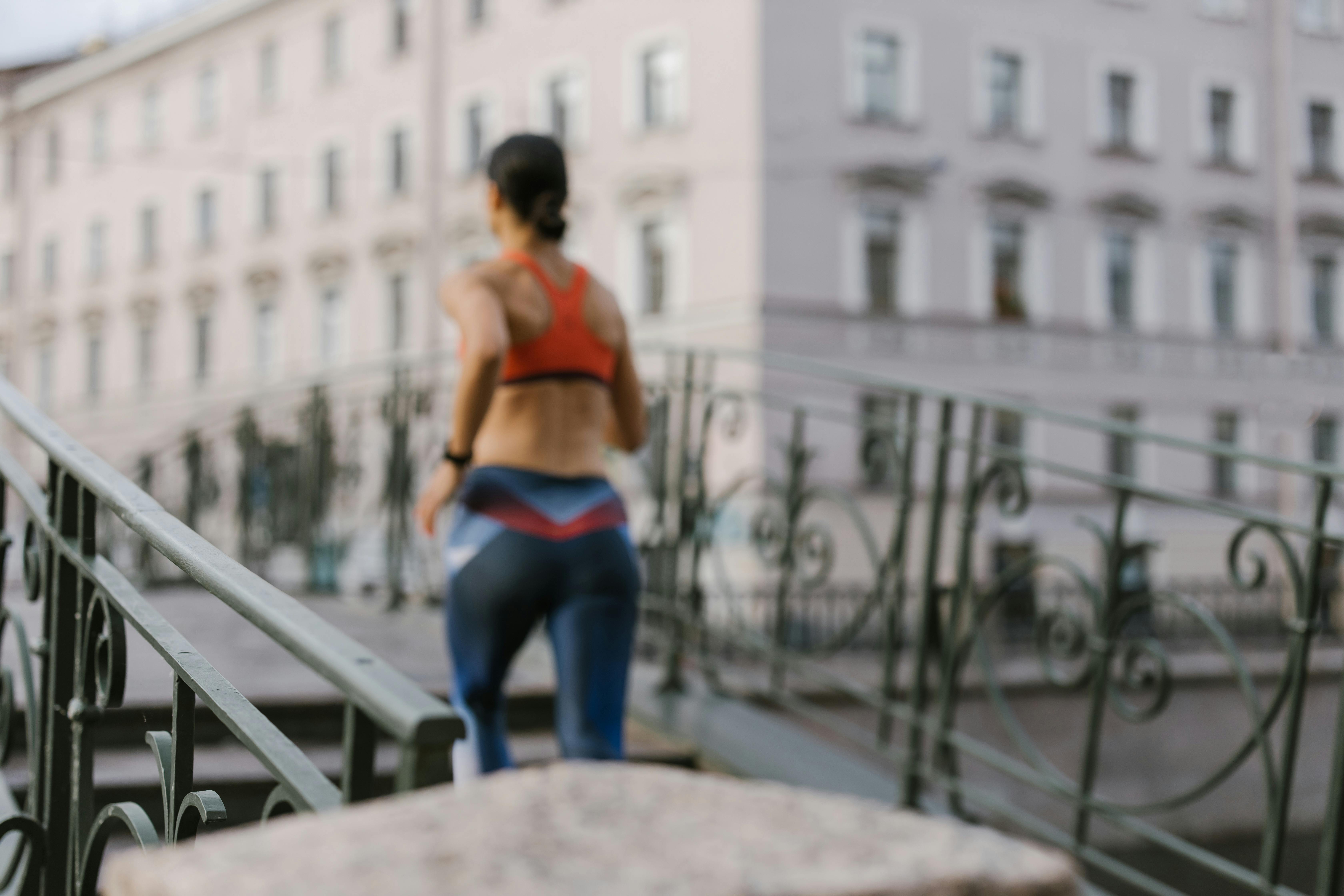 a back view of a woman jogging at the bridge