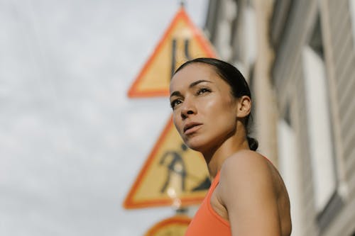A Low Angle Shot of a Woman in Orange Tank Top