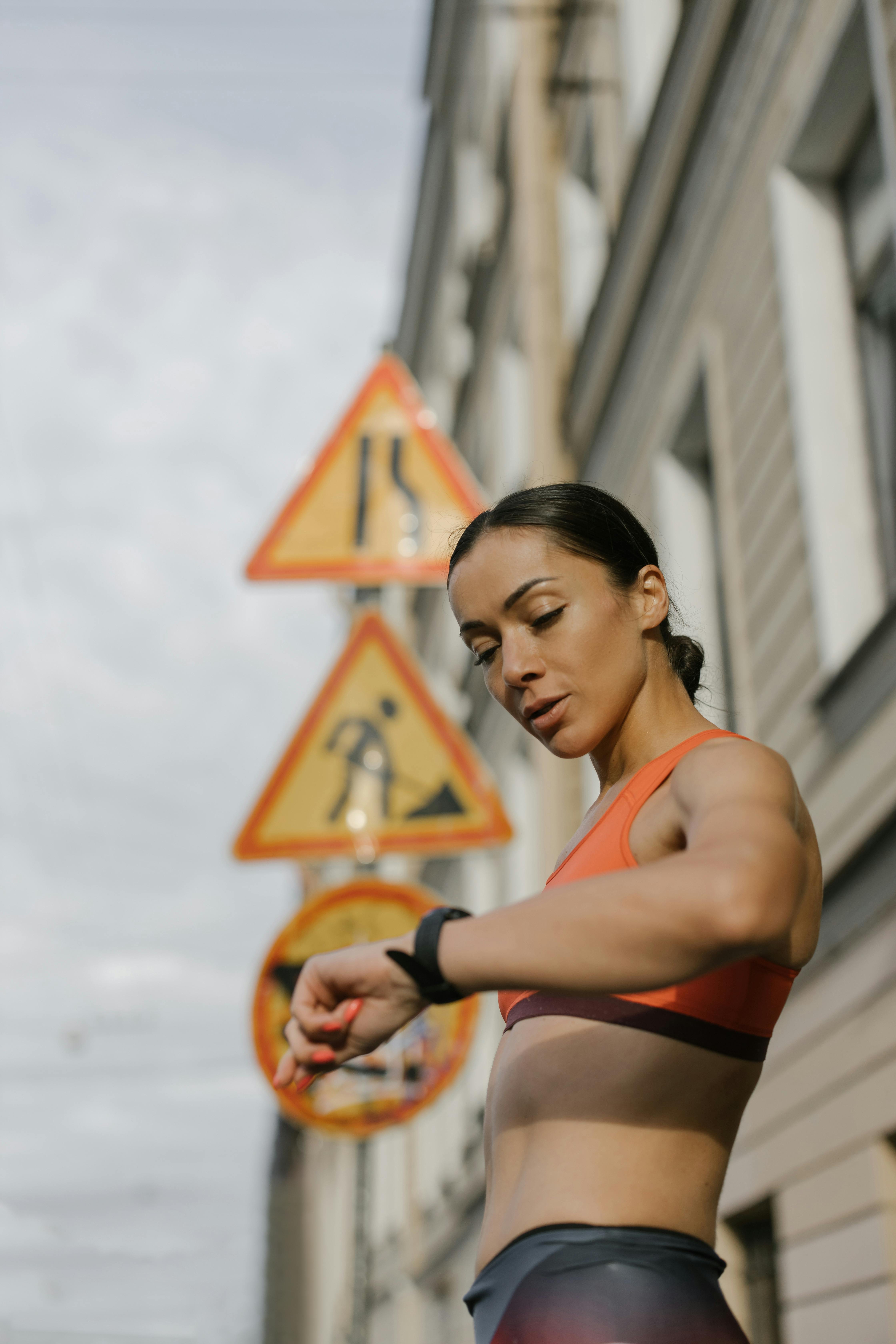 a woman in orange sports bra looking at the time