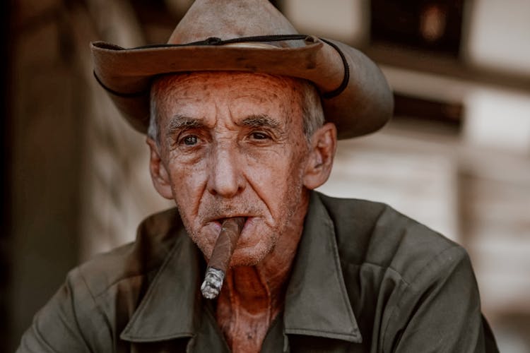 Elderly Man In Hat Smoking Cigar