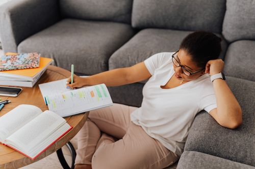 Free Tired African American woman studying with notebooks at home, resting on sofa. Stock Photo