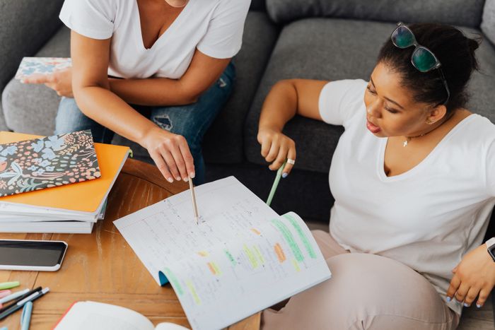 Two students discussing notes