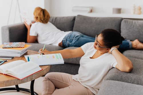 Free Two women studying and resting in a cozy home setting, ideal for education themes. Stock Photo
