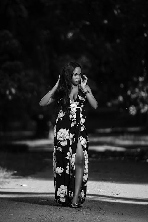 Elegant black woman in long dress walking in park
