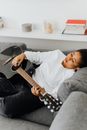 Woman Resting on a Gray Couch while Holding a Guitar