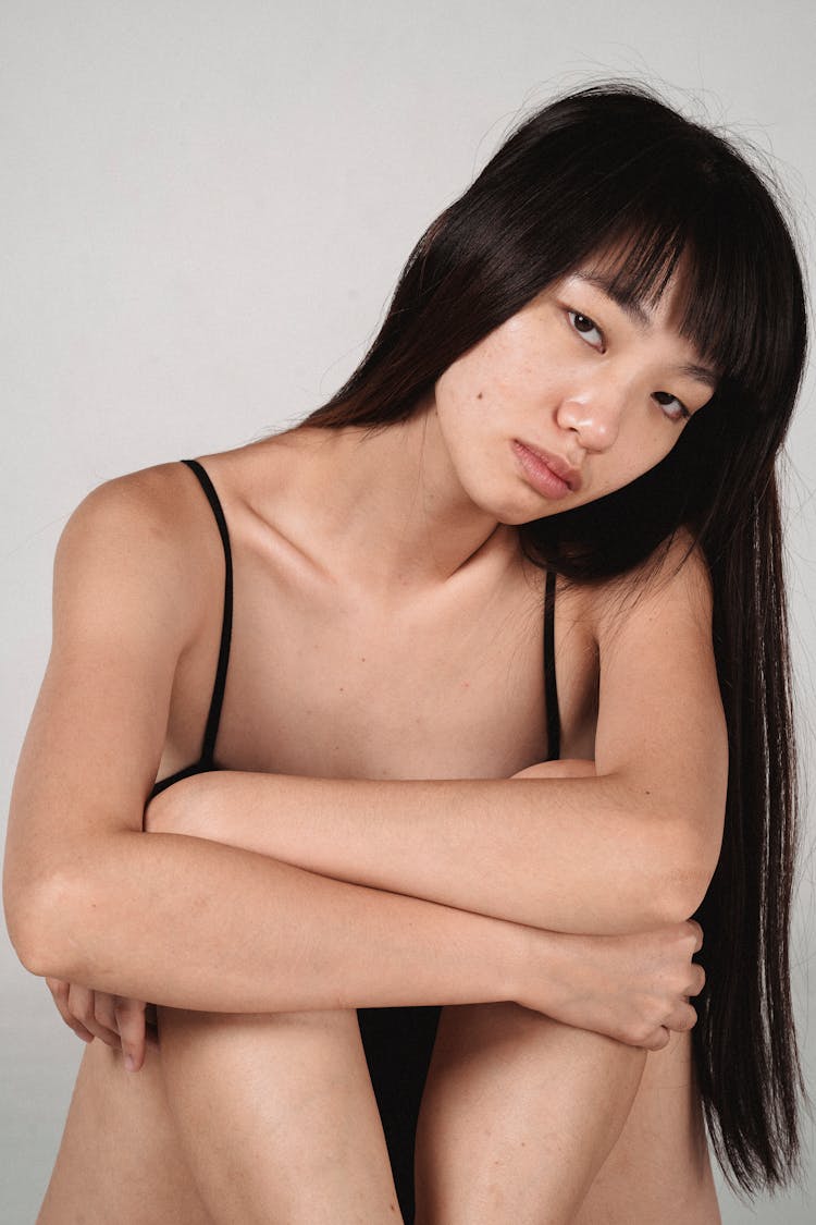 Seductive Asian Model With Tilted Head Near Wall