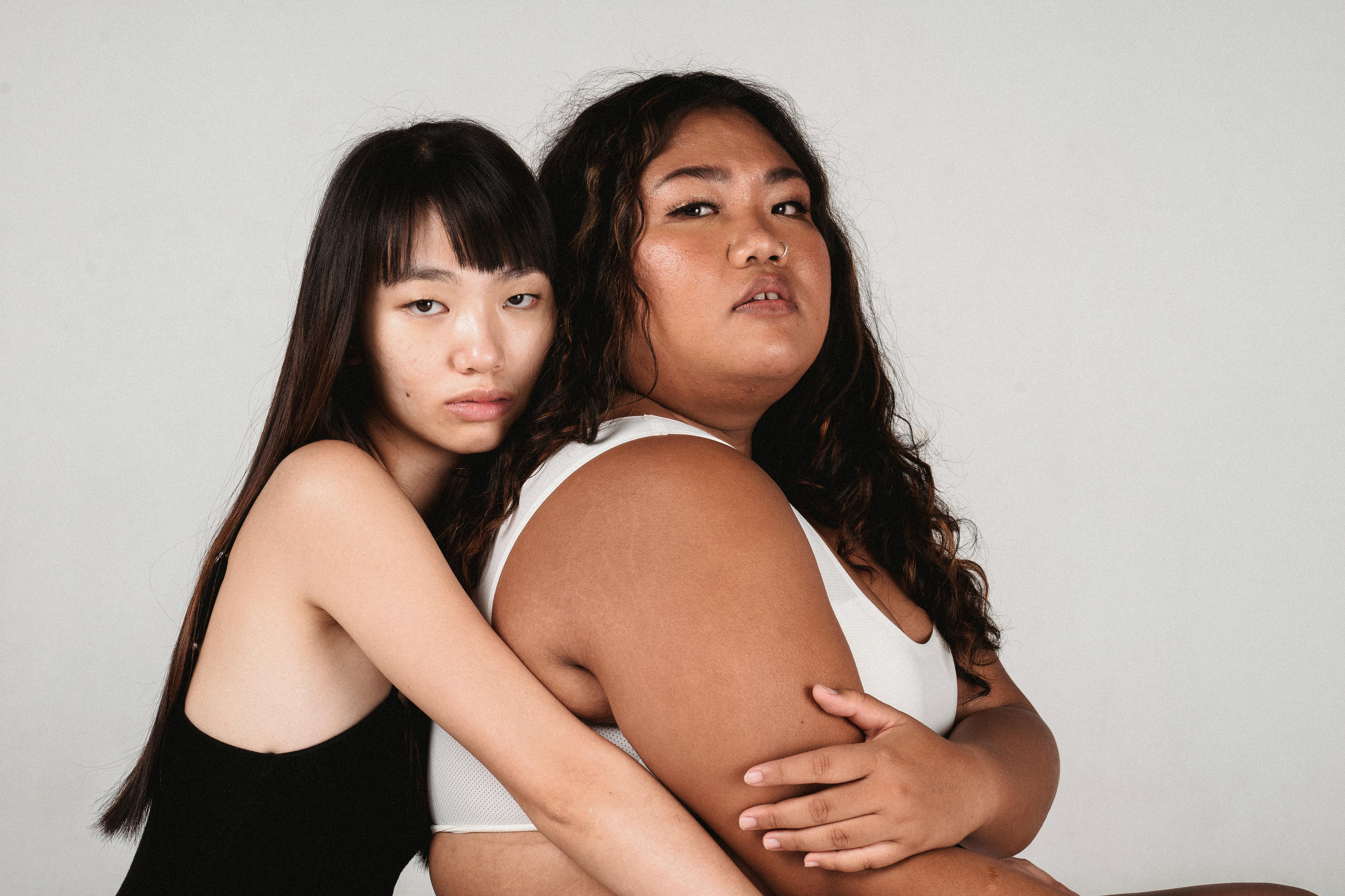 Sensual contemplative Asian lesbian couple in underwear resting on floor ·  Free Stock Photo