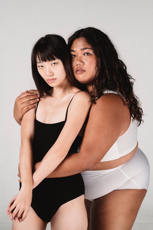 Overweight and slender women in underwear hugging · Free Stock Photo