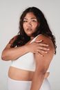 Young plus size Asian woman touching arm