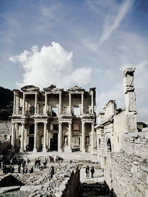 Free From below of old town with stone constructions and columns under sky with clouds in Turkey Stock Photo