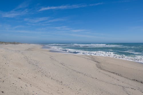 Sand Beach near Blue Splashing Ocean