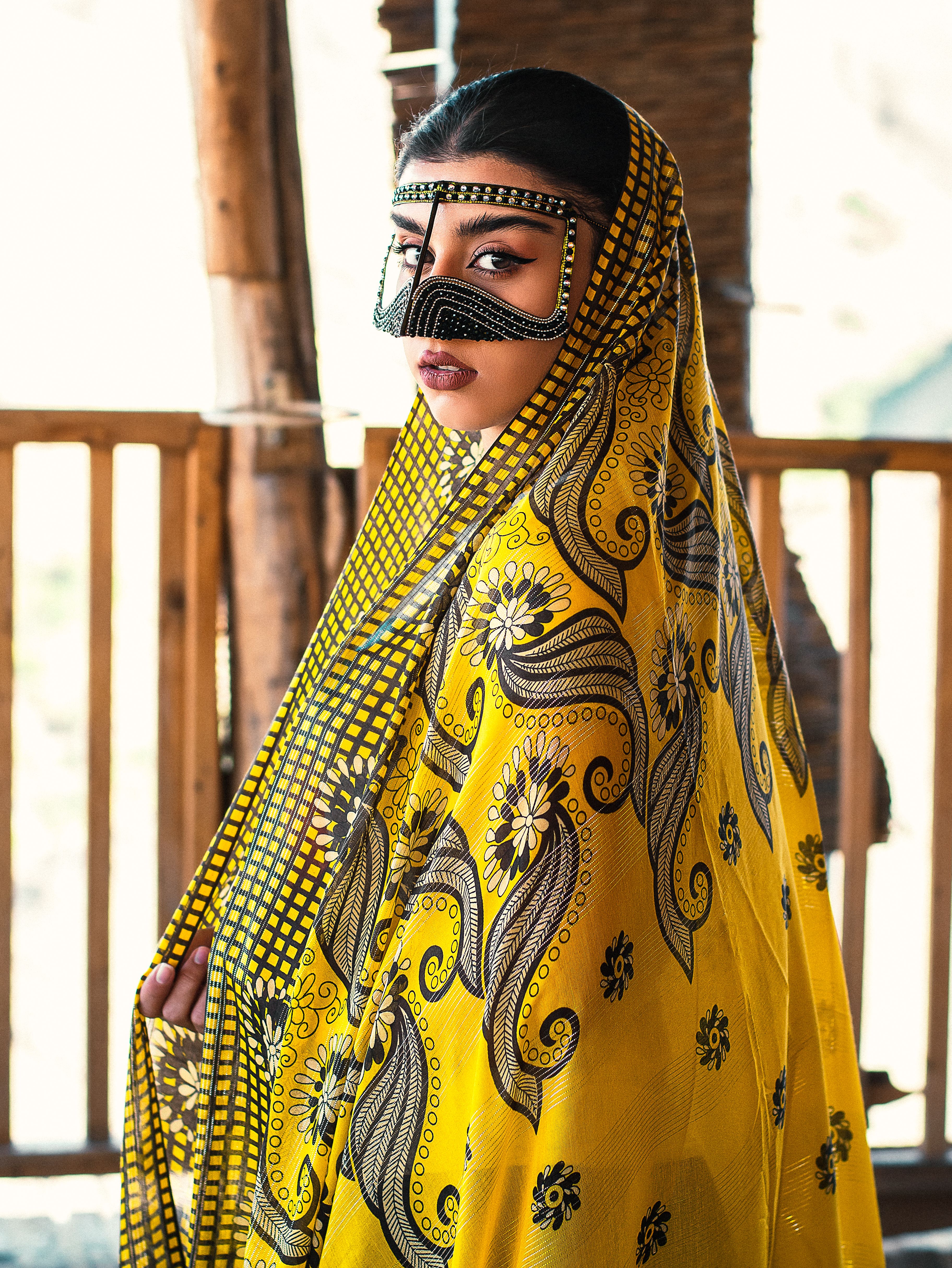 Portrait of woman in vibrant Iranian attire and mask, showing cultural elegance.