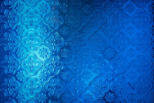 Detailed blue patterned glass surface with ornate designs creating a stylish decoration element.