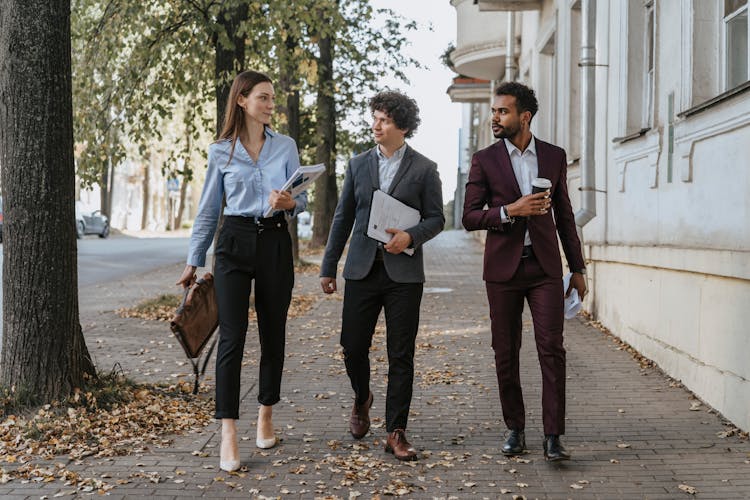 People Walking On The Sidewalk While Talking 