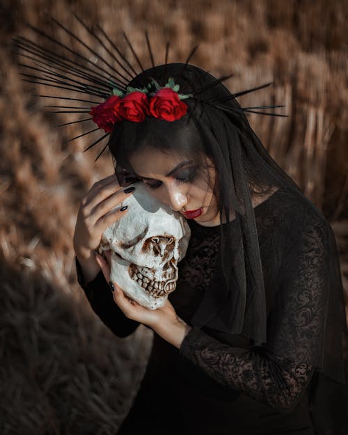 Woman in Black Long Sleeve Shirt Holding White Skull