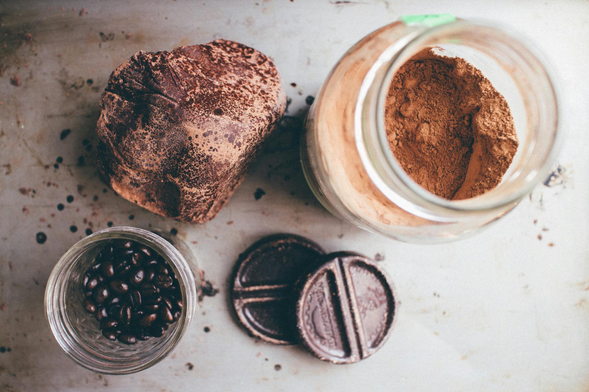 Top view of artisanal chocolate, cocoa powder, and coffee beans arranged in a rustic style.