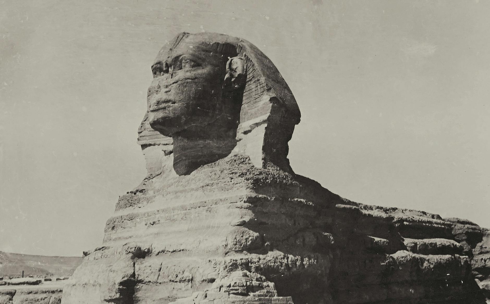Historic monochrome image depicting the Great Sphinx of Giza, an iconic Egyptian limestone statue.