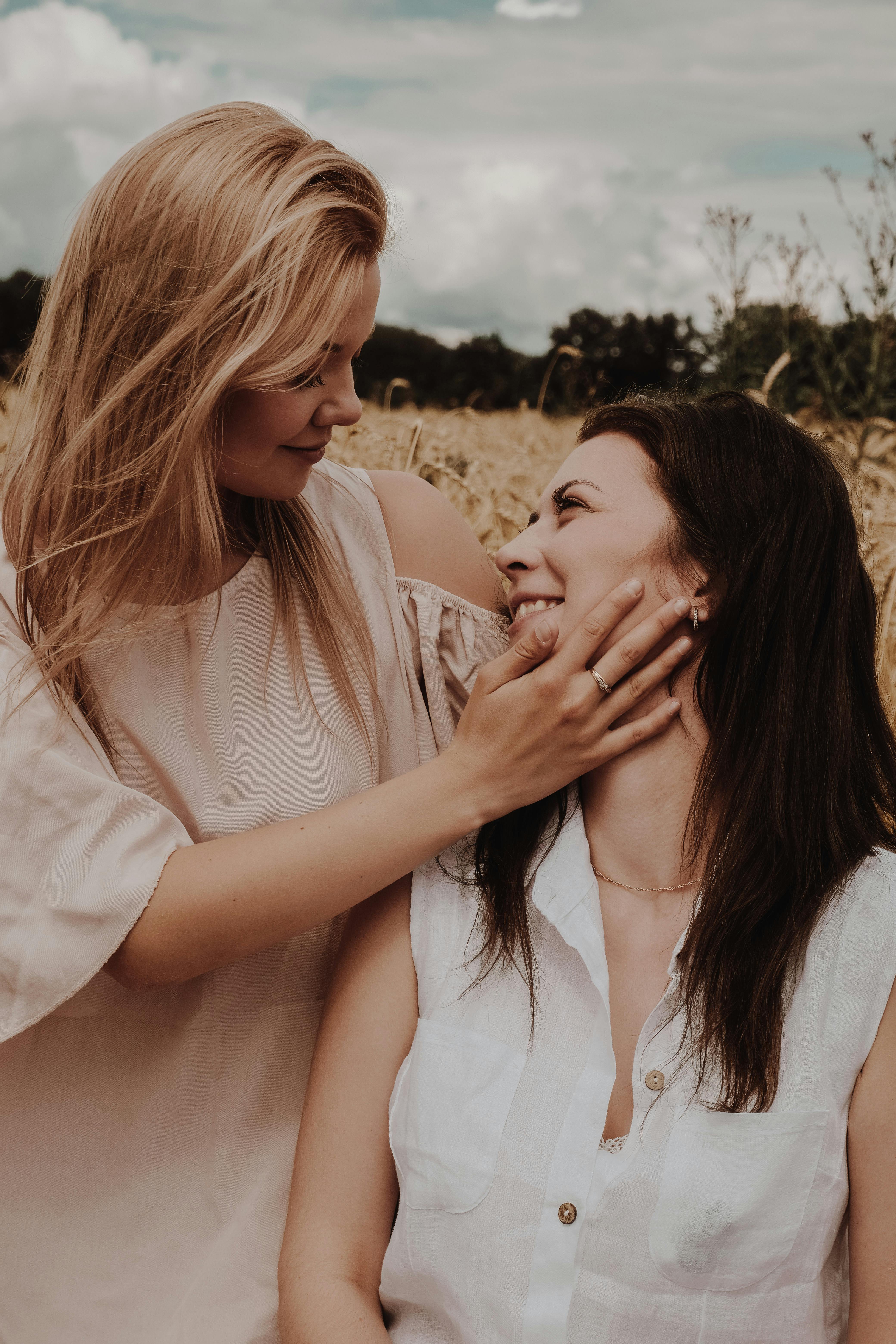 loving female couple caressing in dry field