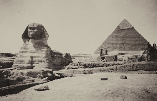 Classic black and white image capturing the Sphinx and Pyramid of Giza, Egypt.