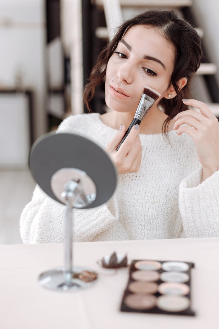 Woman Applying Blush On On Her Cheek