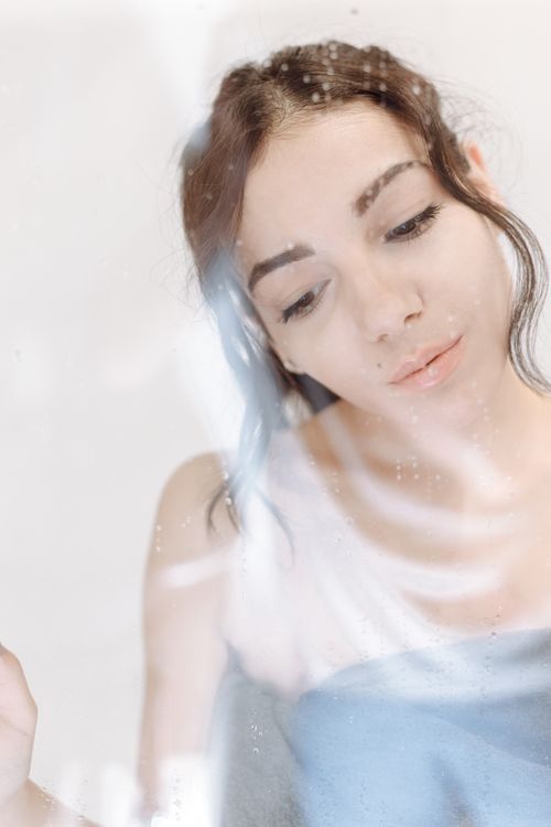 Free Soft focus portrait of a woman behind glass, creating a dreamy, ethereal effect. Stock Photo