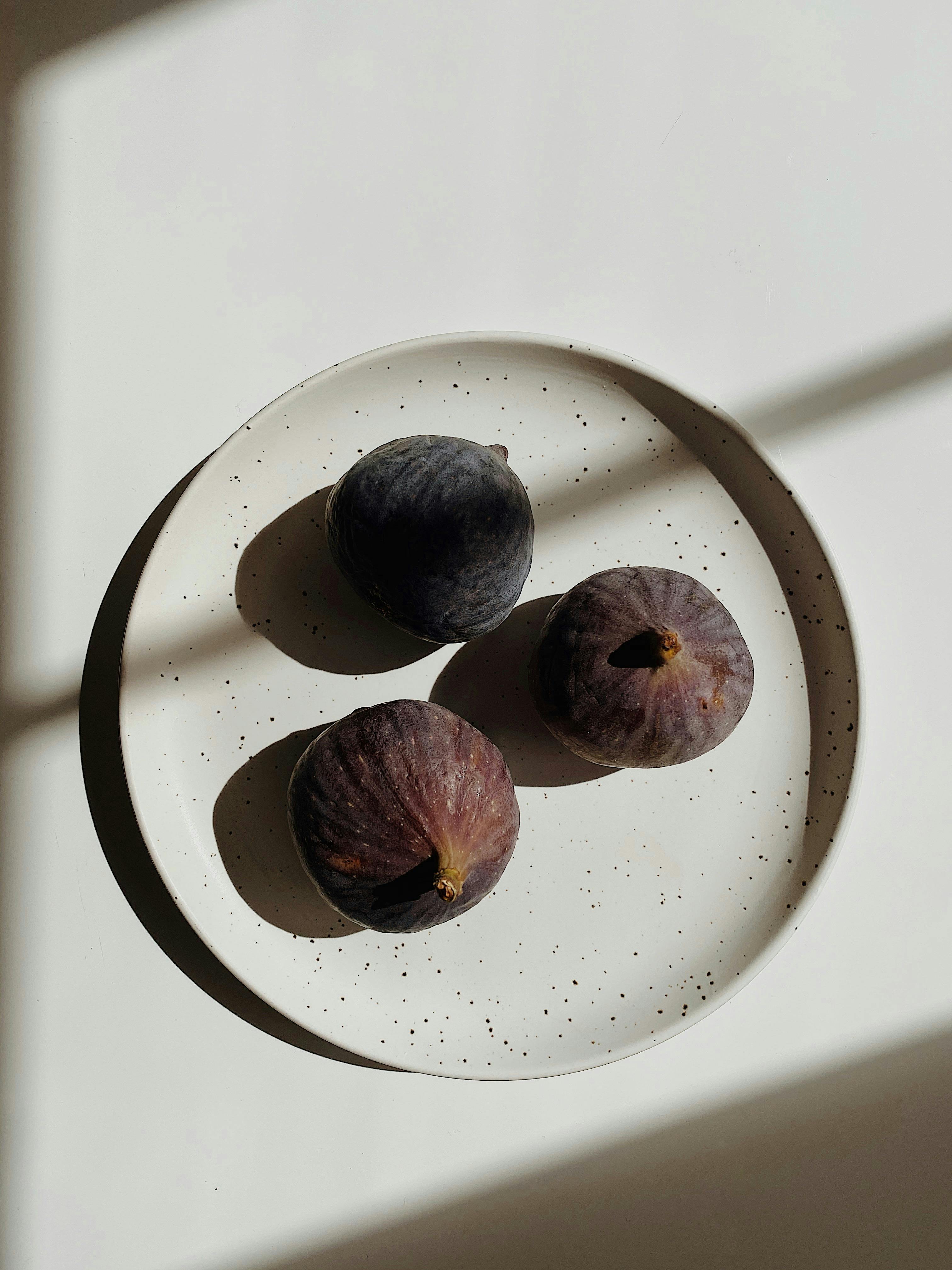 fresh fig on plate in shadows
