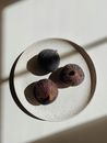 Top view of ripe unpeeled fig fruits placed on white ceramic bowl