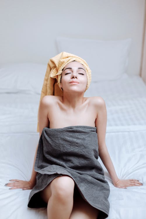 Free Woman in Towel Sitting on Bed  Stock Photo