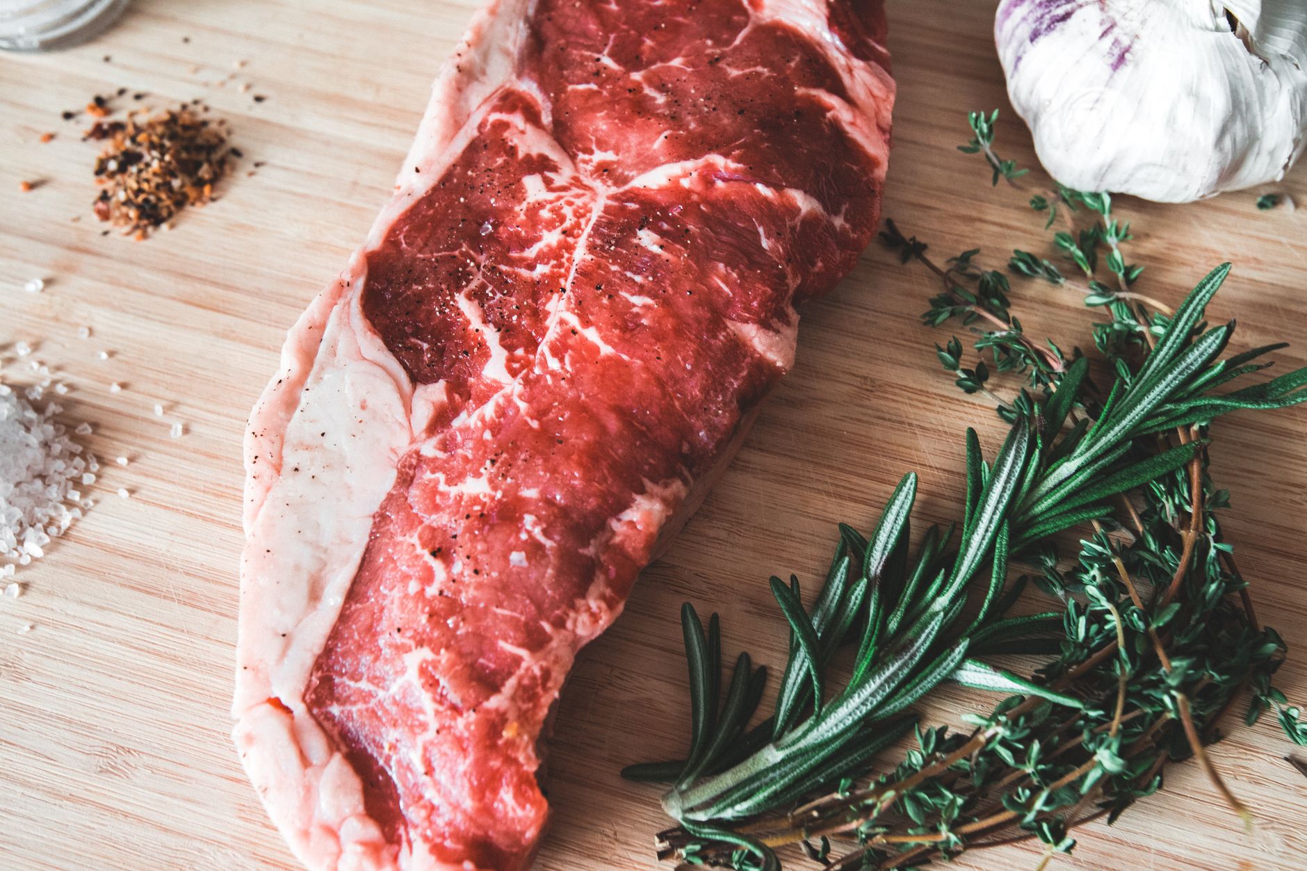 Sizzling New York Strip Steak on a cast iron pan