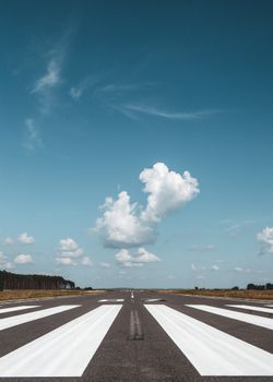 A clear runway with vibrant sky and clouds perfect for travel and aviation themes.