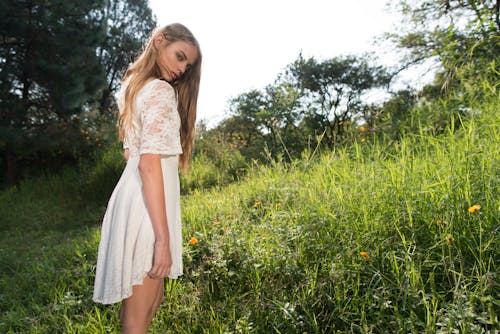 Woman in White Dress Standing on Tall Grass 