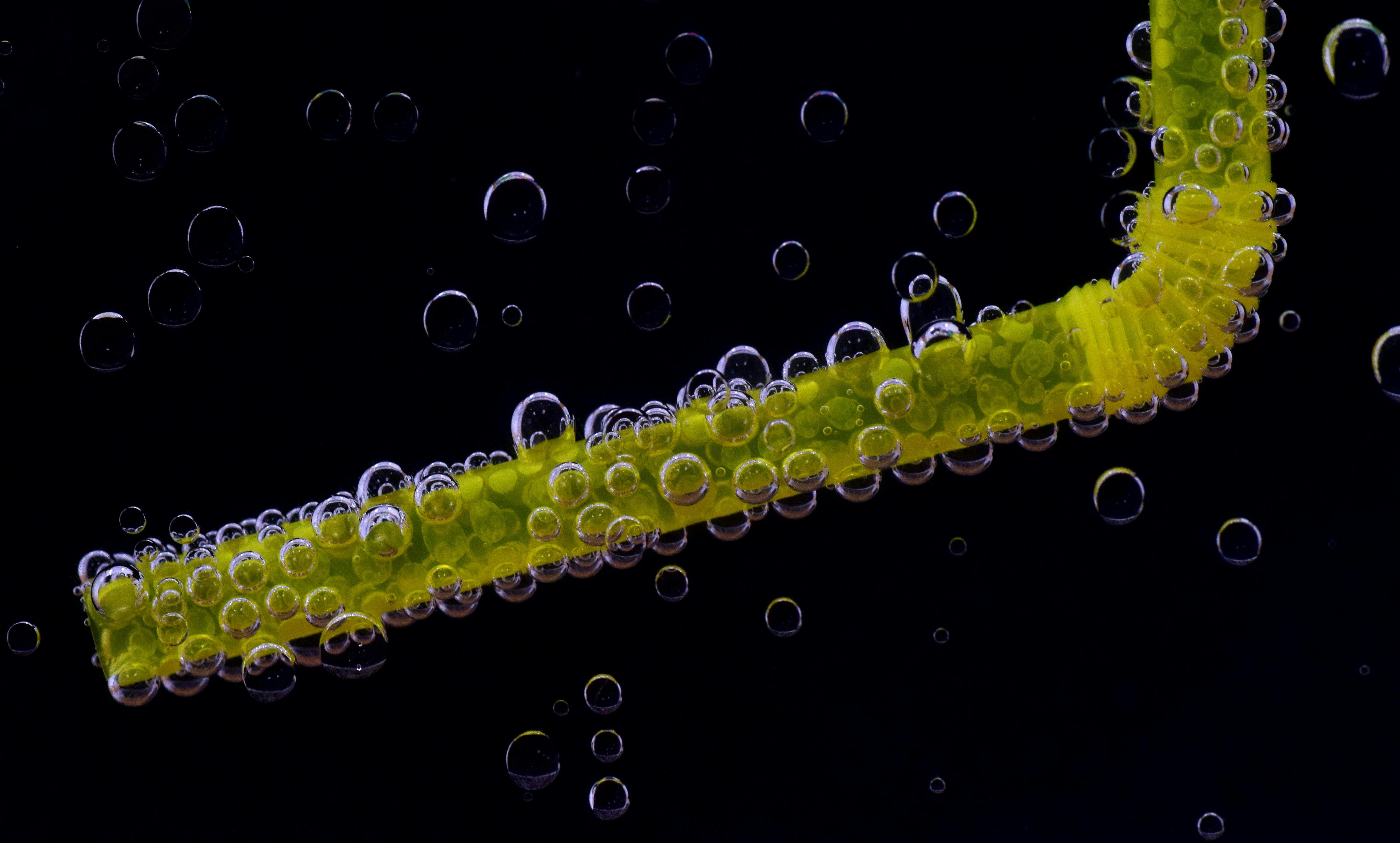 green drinking straw surrounded by bubbles