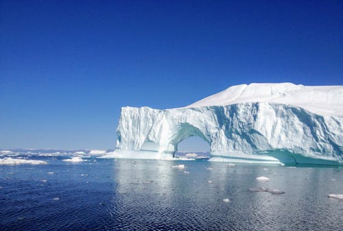 An Iceberg on the Sea Under Blue Sky