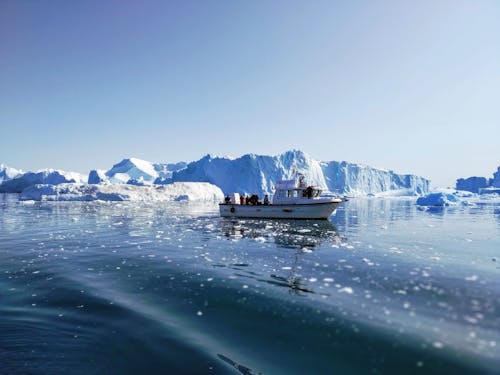 Boat on Body of Water Near Icebergs