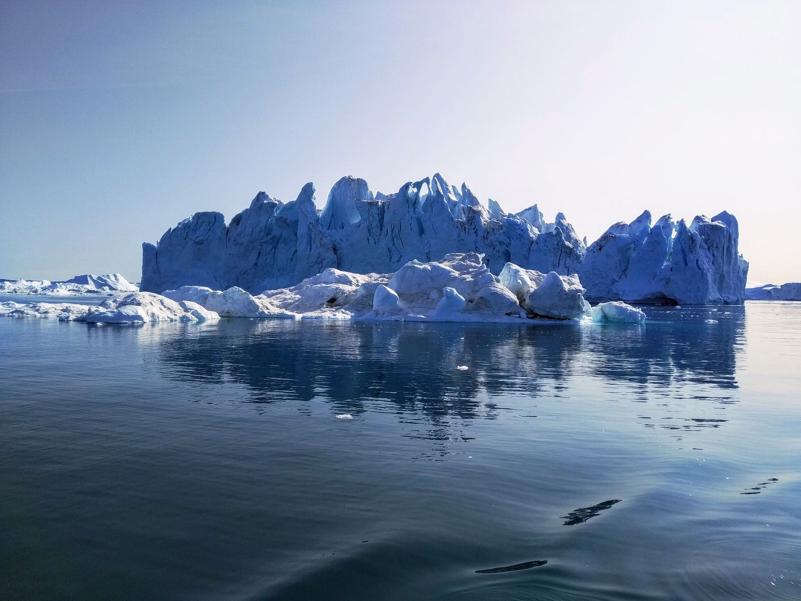 Large iceberg floating in calm Arctic waters off Greenland, illustrative photo of the ice shelf disaster that drives Digger's plot
